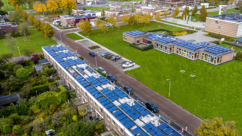 Zonnepanelen op daken van een school en een flat
